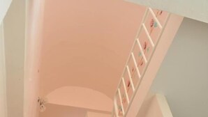 Una escalera con barandilla y un accesorio de iluminación en la parte superior.
