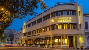 The Chambers Hotel Restaurant with a curved facade, large windows, and a prominent sign. - The Chambers (George Town)