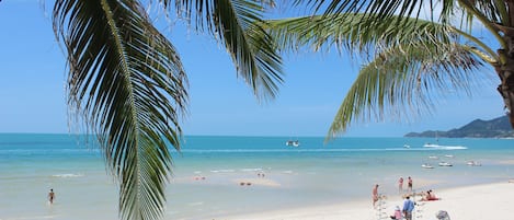 Na praia, guarda-sóis, toalhas de praia