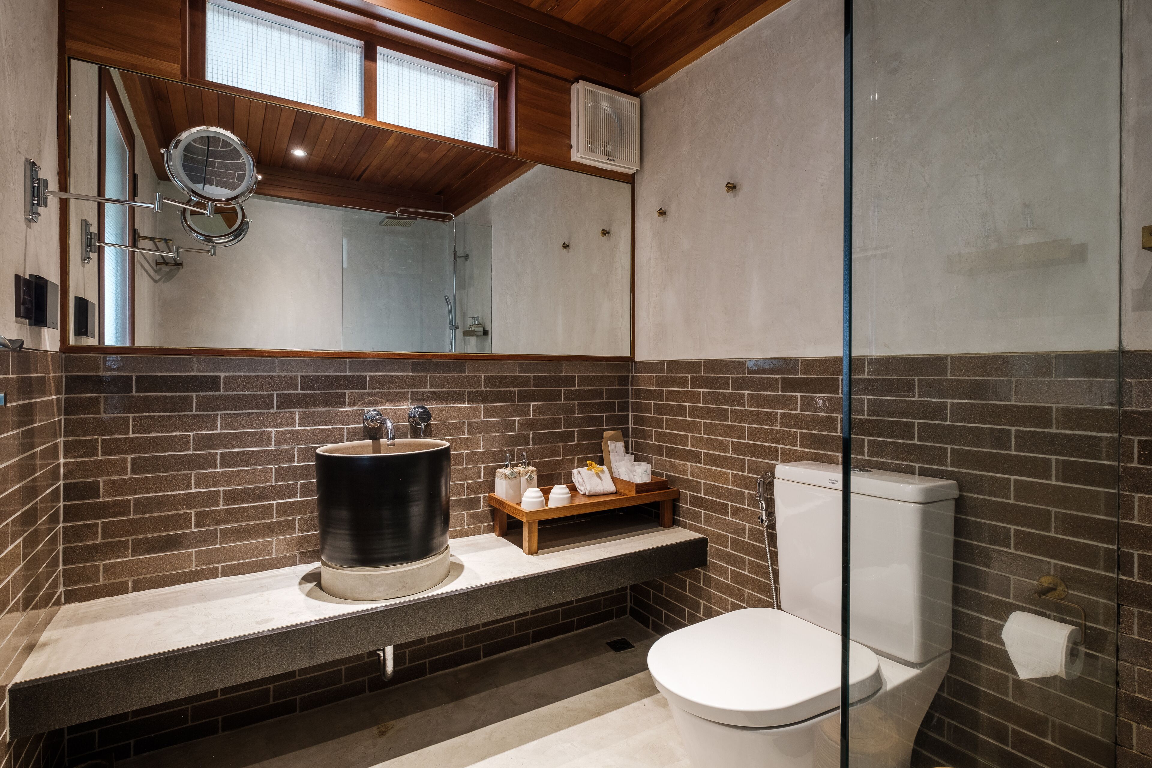 Een moderne badkamer met een grote spiegel, een wastafel en een toilet.