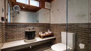 A modern bathroom with a large mirror, a sink, and a toilet.