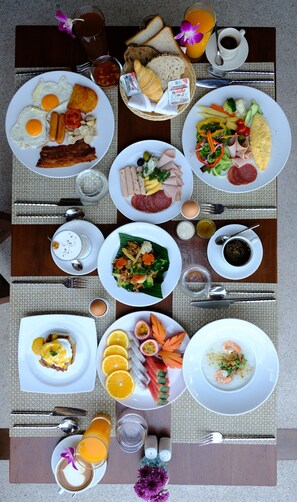 A breakfast buffet with various dishes, drinks, and condiments. - Banana Fan Sea Resort (Koh Samui)
