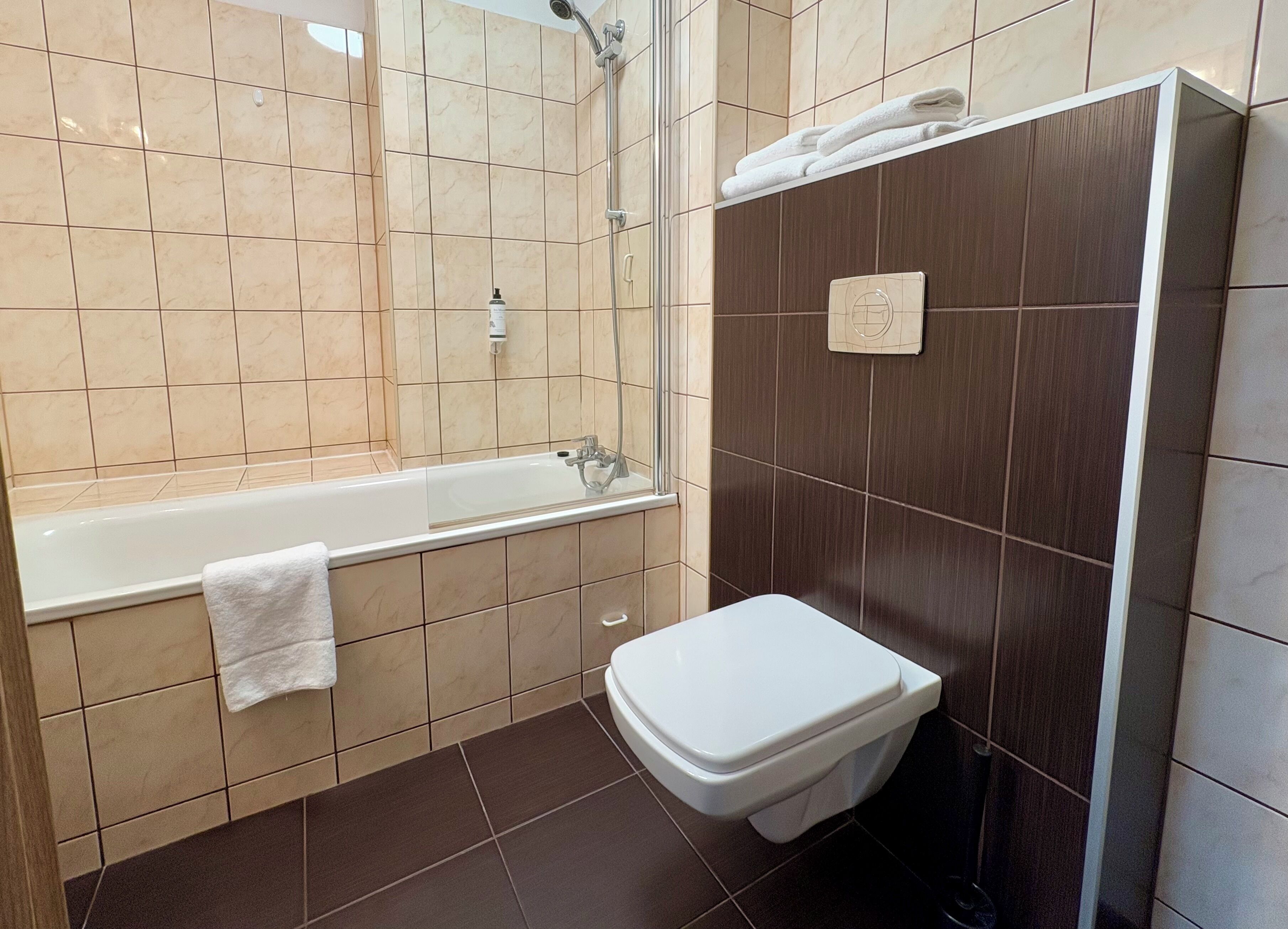 Un baño con bañera, inodoro y ducha.