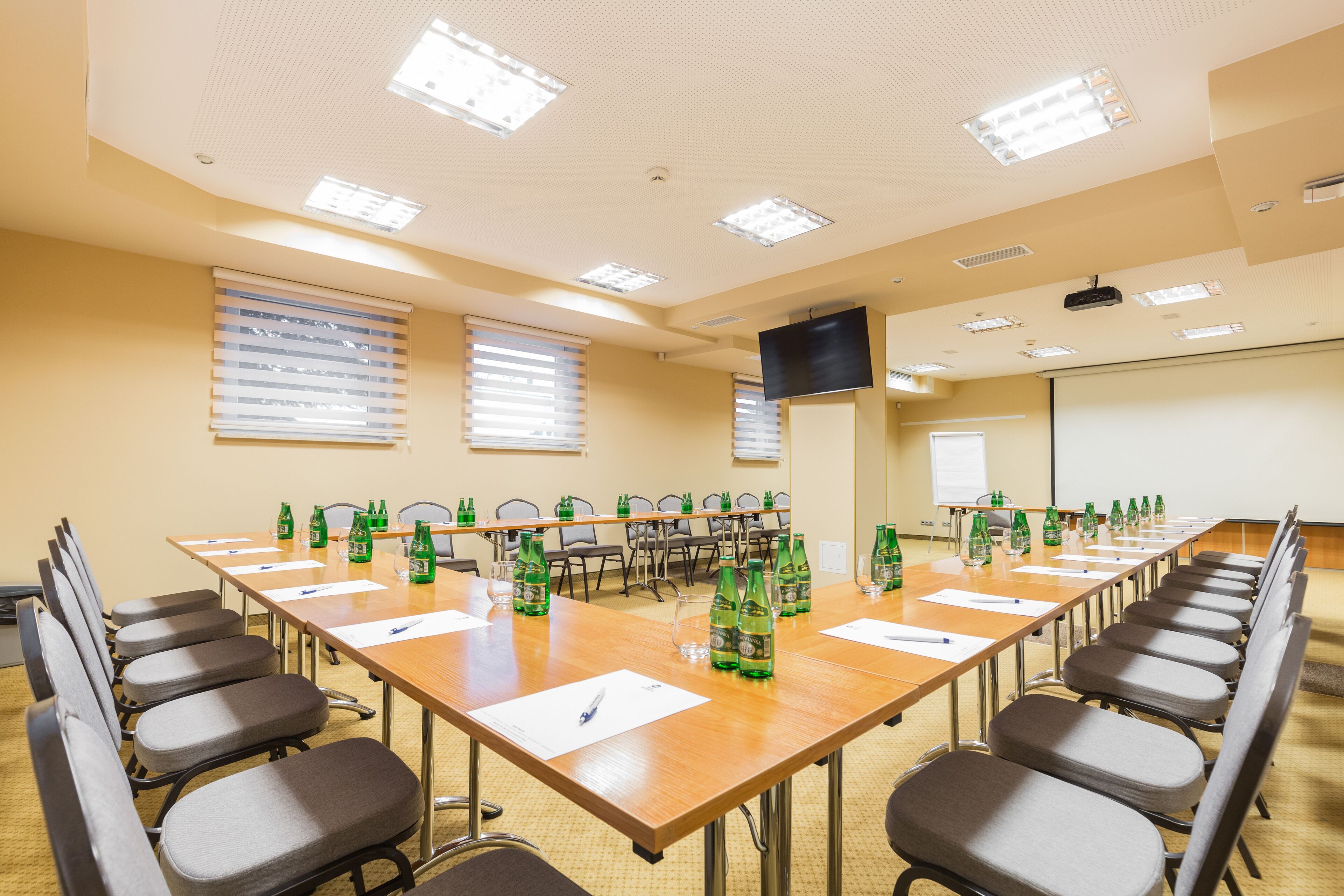 A conference room with a long table, chairs, and water bottles.
