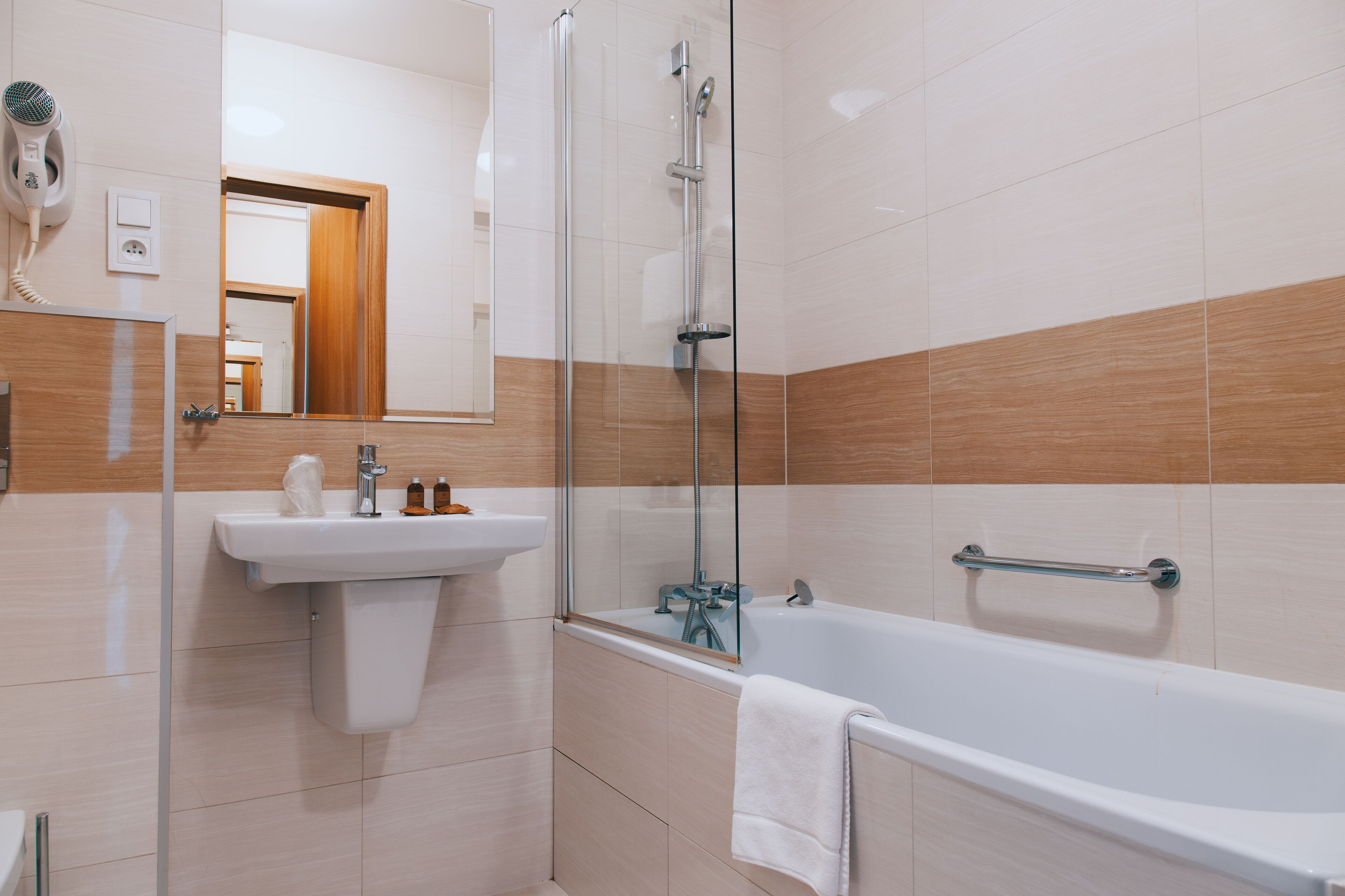 Ein modernes Badezimmer mit einer Duschkabine, einem Waschbecken und einer Badewanne.