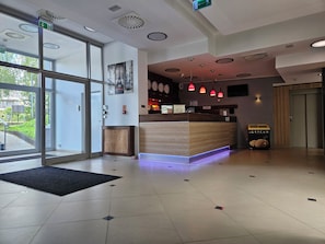 A hotel reception area with a reception desk, a digital clock, and a fire alarm. - POLECZKI RESIDENCE APARTMENTS  (Warsaw)
