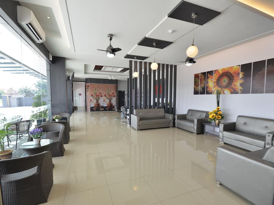 A modern lobby with seating areas, a reception desk, and a large window providing a view of the outdoors.