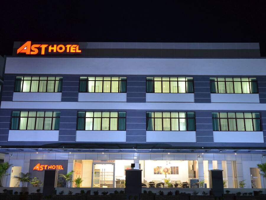 A multi-story hotel with a modern facade, large windows, and a prominent 'Ast Hotel' sign.