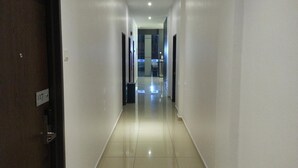 A clean, well-lit hallway with a tiled floor leading to a reception area. - AST Hotel (Alor Setar)