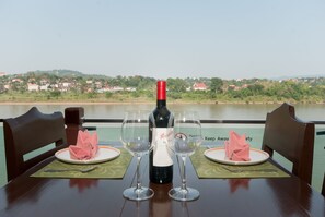 A table set with a bottle of wine, two glasses, and pink napkins.