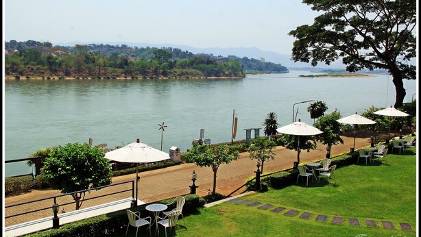 A riverside terrace with outdoor seating and a view of the river. - Namkhong Riverside Hotel Chiang Rai (Chiang Khong)