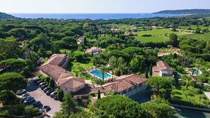Une villa avec piscine, entourée d’une végétation luxuriante et offrant une vue sur la mer.