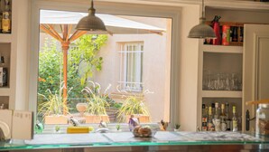 Une cuisine dotée d’une grande fenêtre, de plantes en pot et de divers ustensiles de cuisine.