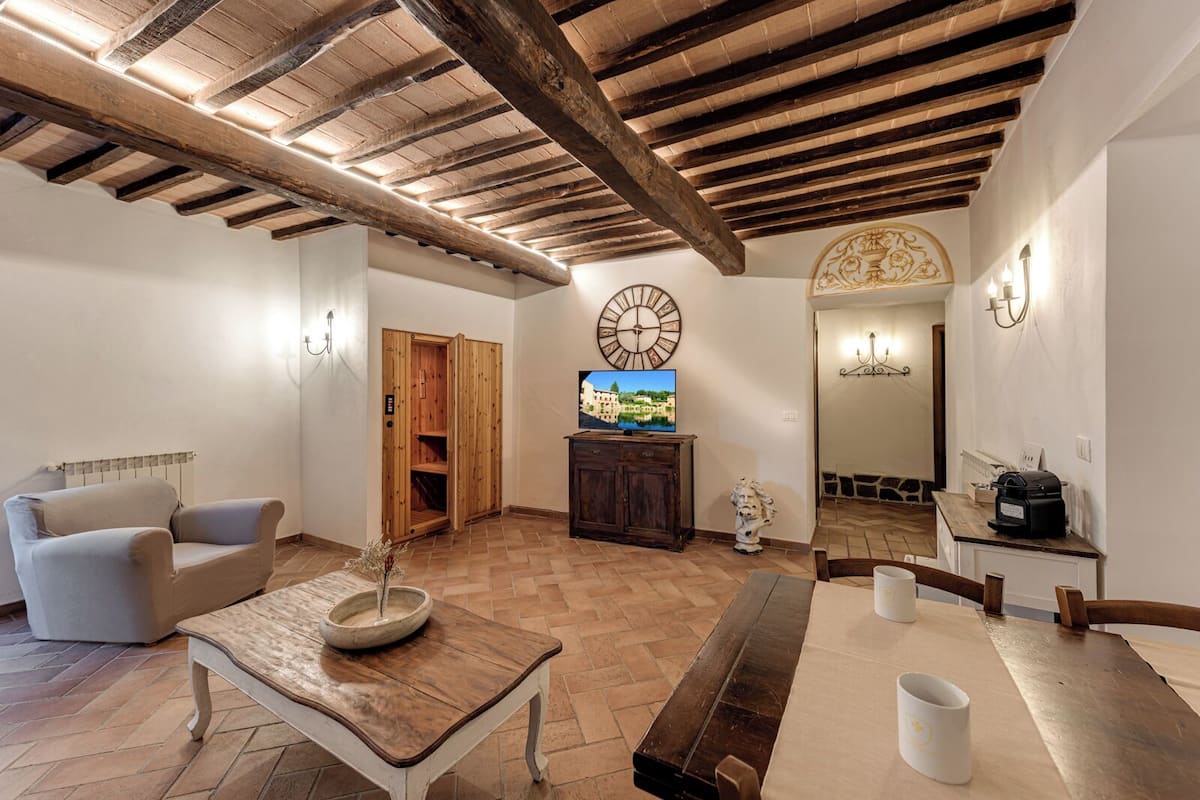A spacious living room with a wooden ceiling, a sofa, a coffee table, a TV, and a wooden cabinet.