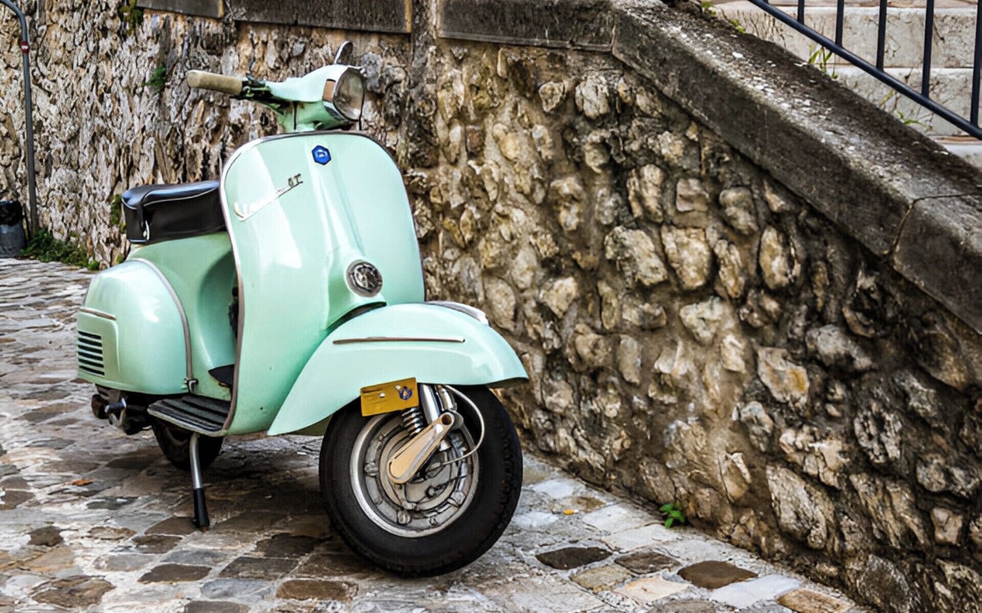 Una moto antigua estacionada en una calle adoquinada.