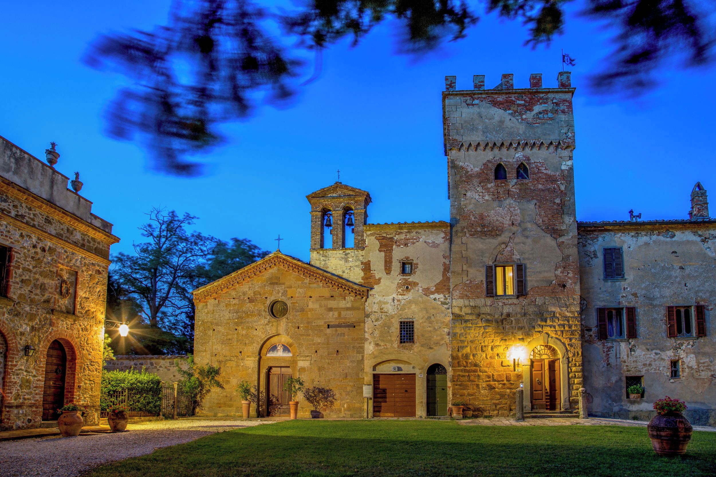 A historic building with a bell tower, arched doorways, and a courtyard.