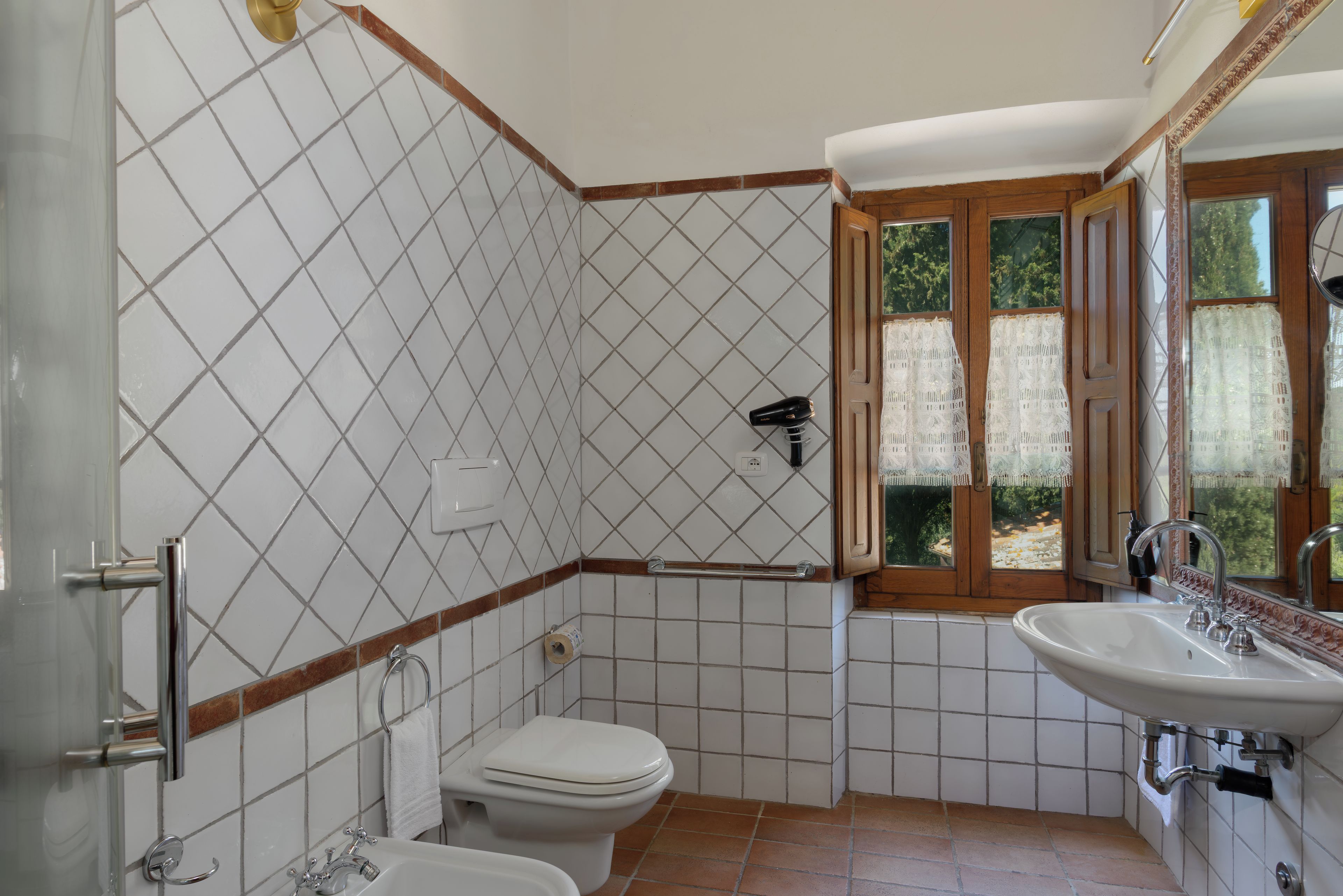 Un baño con inodoro, lavabo y zona de ducha.