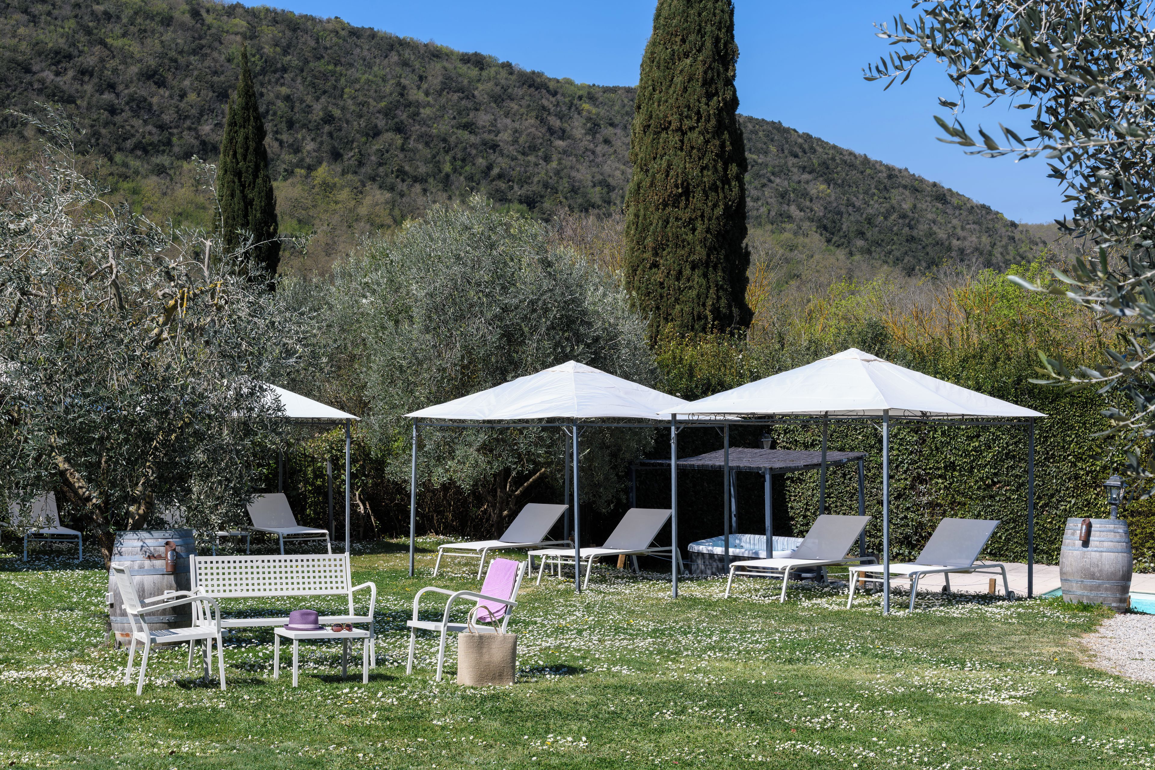 Un espace extérieur aménagé avec des parasols, des chaises et une table.