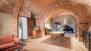 A spacious room with a pool table, a sofa, and a grand piano. - Abbadia Sicille Relais (Trequanda)