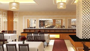 Un comedor con mesas y sillas, una barra con un fondo estampado, y una pared decorativa con diseño de celosía.