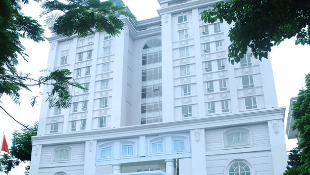 Un hotel grande de varios pisos con una entrada imponente y un letrero llamativo.