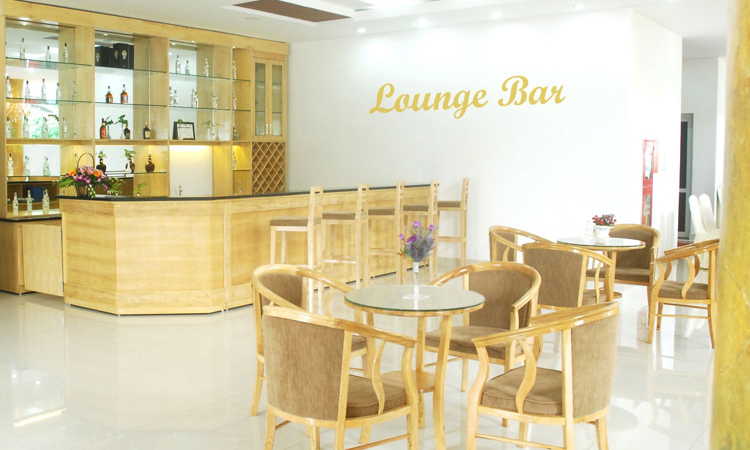 A lounge bar with wooden furniture and a glass display case.