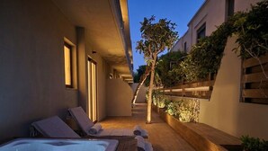 Un espace bien-être comprenant un jacuzzi, des chaises longues et une terrasse en bois.