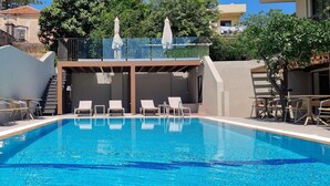 A swimming pool with lounge chairs and a covered area. - Mariette Rhodes Urban Suites  (Rhodes)