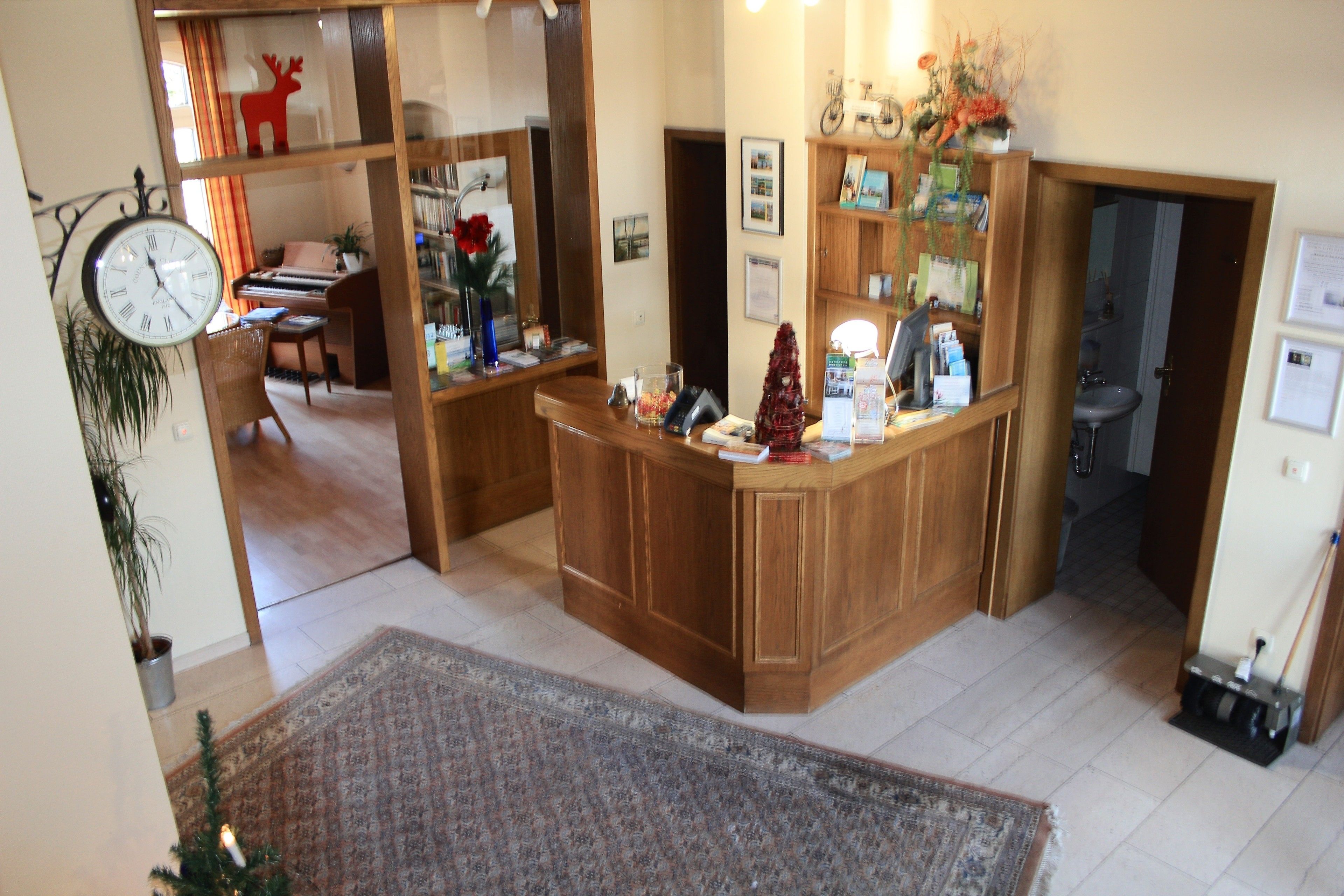 Una cocina con mostrador de madera, un reloj y un piano al fondo.