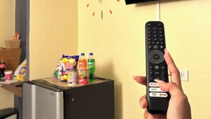 A hand holding a remote control with a TV displaying the Netflix logo in the background. - The Avail (Ayutthaya)