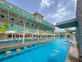 Una piscina al aire libre, sillones reclinables de piscina