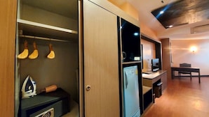 A modern kitchen with a built-in refrigerator, a microwave, and a stove. There is a wooden cabinet with a glass door containing kitchen utensils. - M Hotel Danok (Sadao)