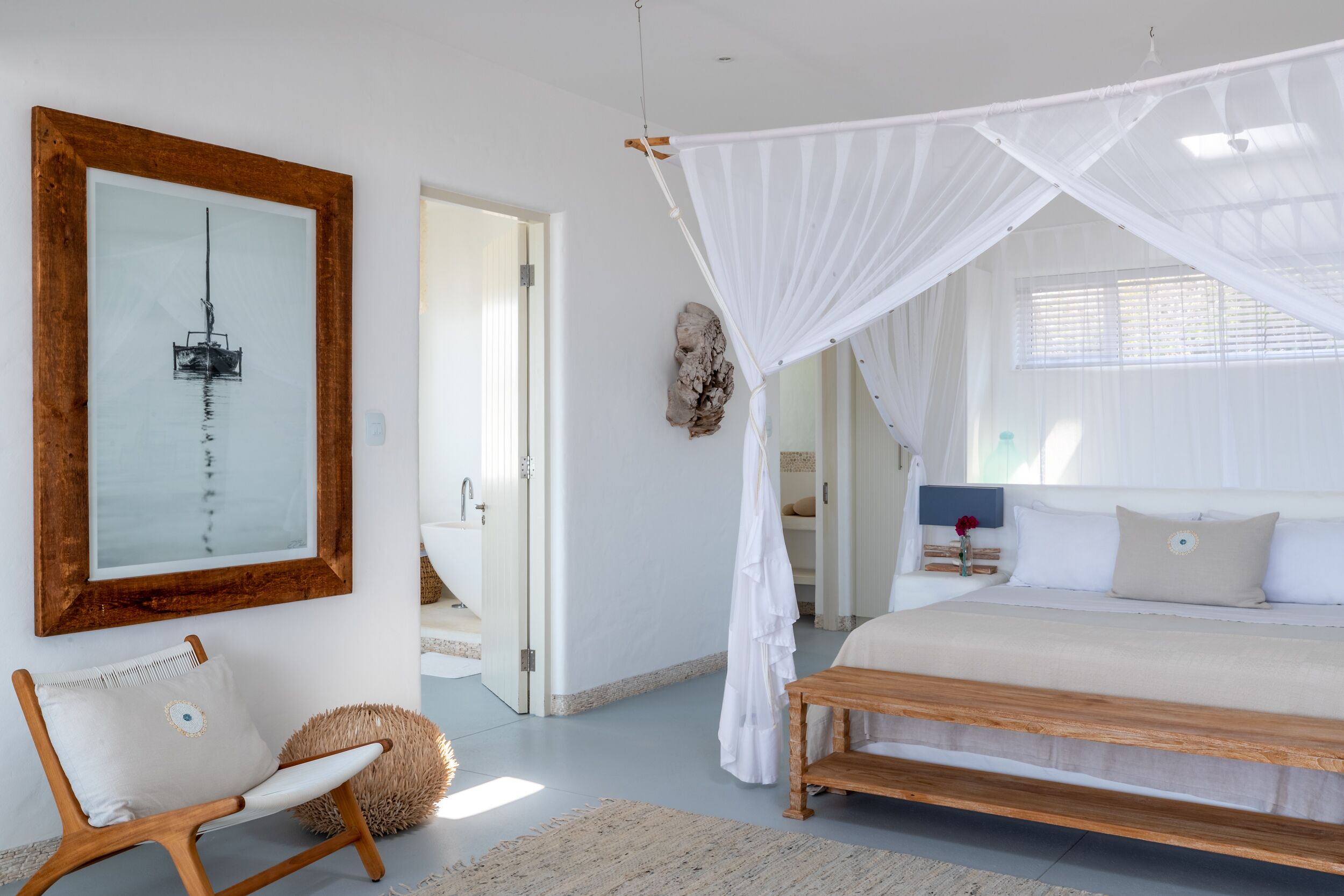 Un dormitorio con cama, una silla, un cuadro y un dosel.