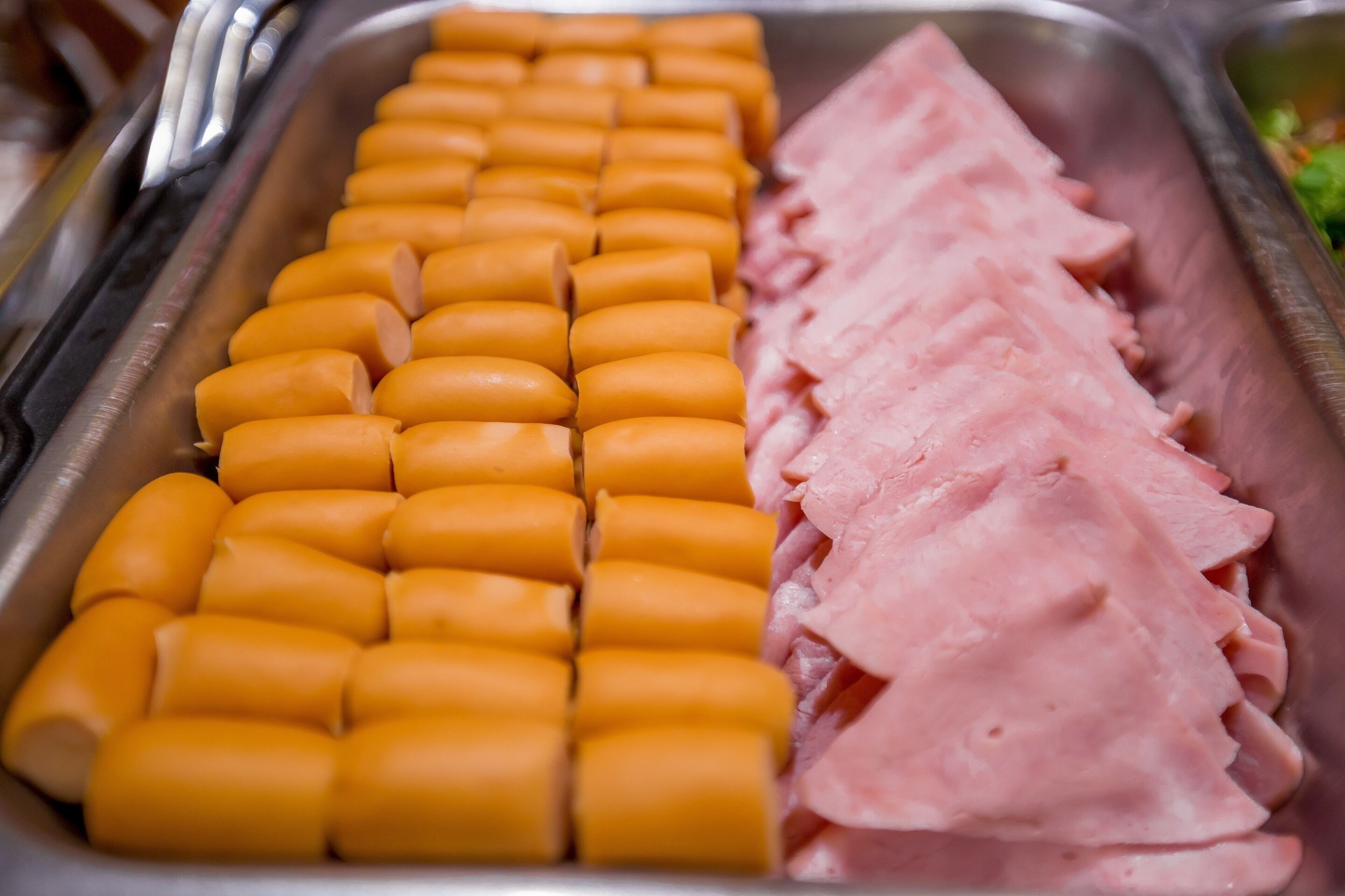 Un buffet où des tranches de jambon et de fromage sont disposées avec soin.