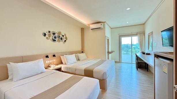 A hotel room with two beds, a desk, a television, and a balcony with a view. - Loei Village Hotel (Mueang Loei)