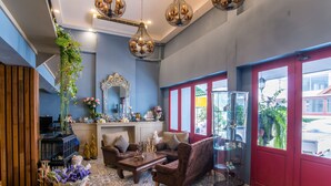 A cozy living room with a sofa, armchair, and coffee table, a mirror, and a hanging plant. - At Ease Bijou Place (Chiang Mai)