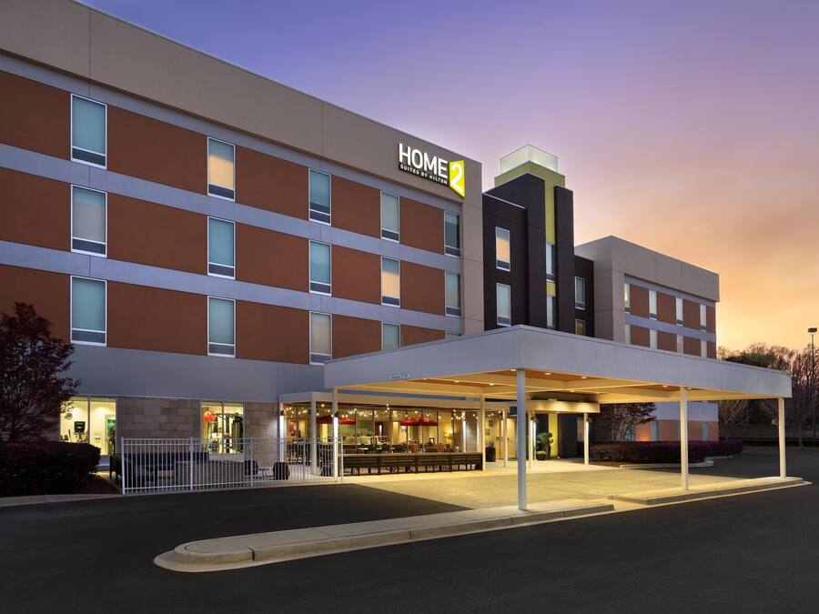 A modern hotel with a covered entrance and multiple floors.