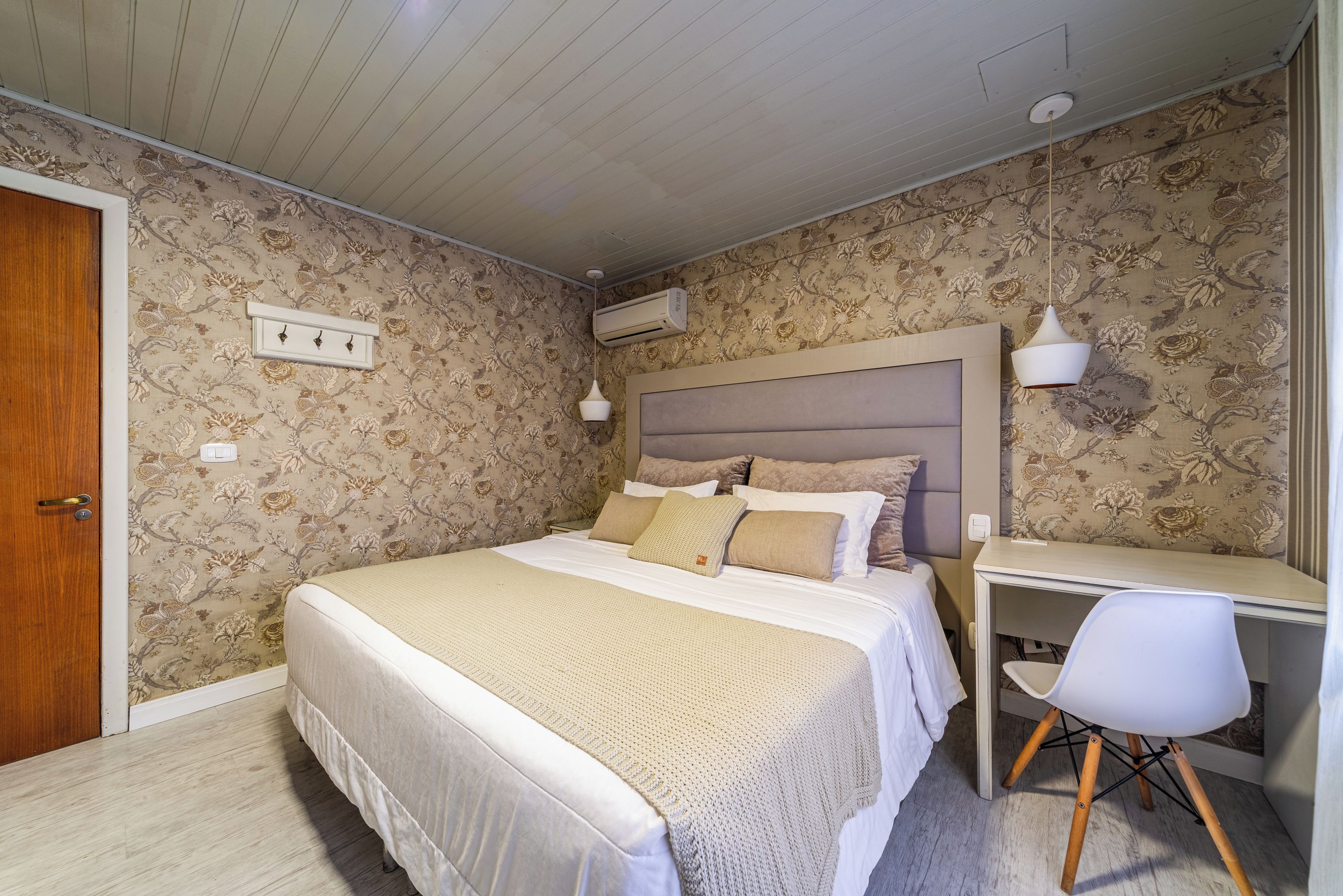 Una camera da letto con un letto, un comodino, una sedia e un condizionatore d'aria.