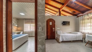 A hotel room with a wooden ceiling, a bed, a desk, and a television. - Hotel Bangalôs da Serra (Gramado)