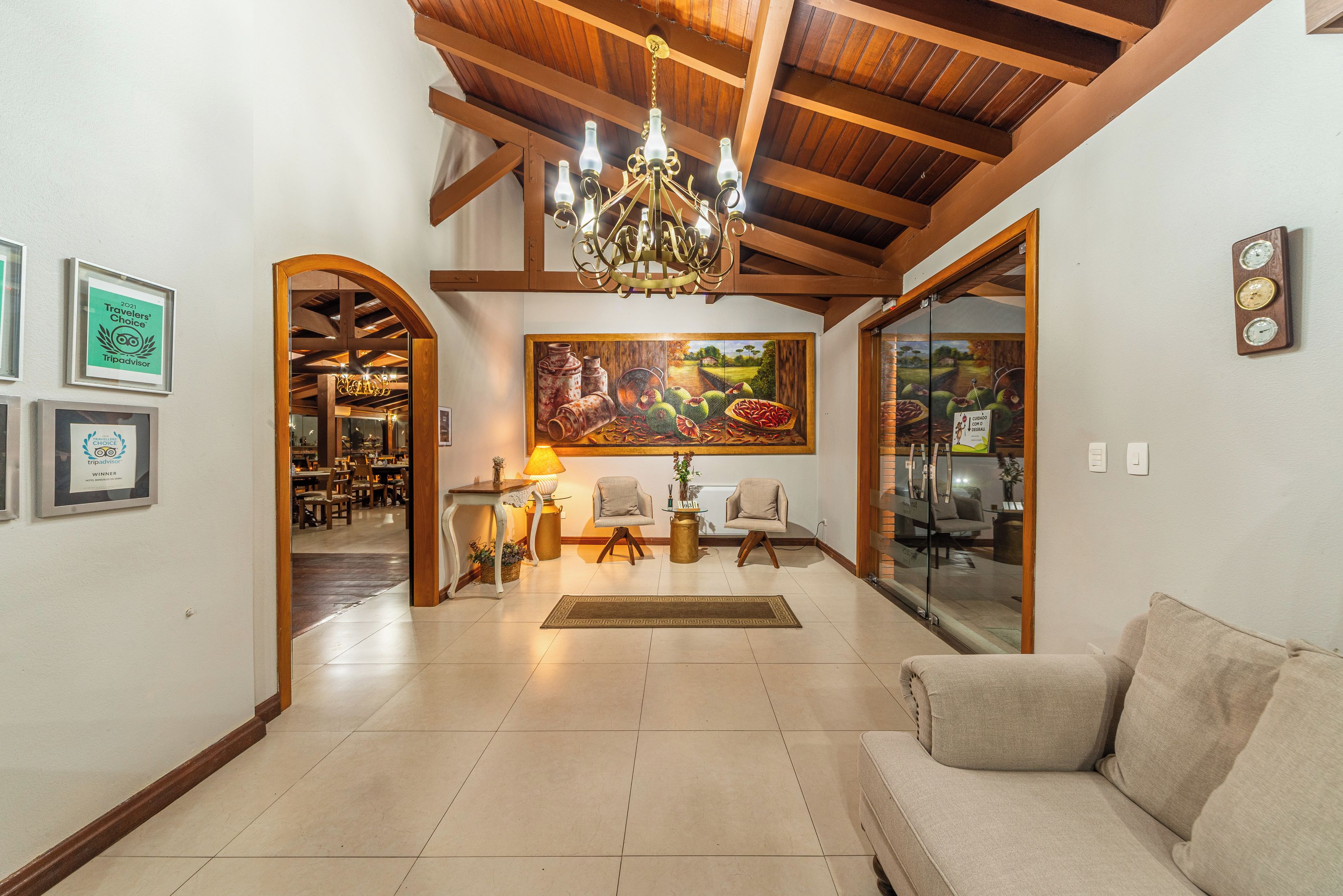 A spacious living area with a chandelier, a painting, and a sofa.