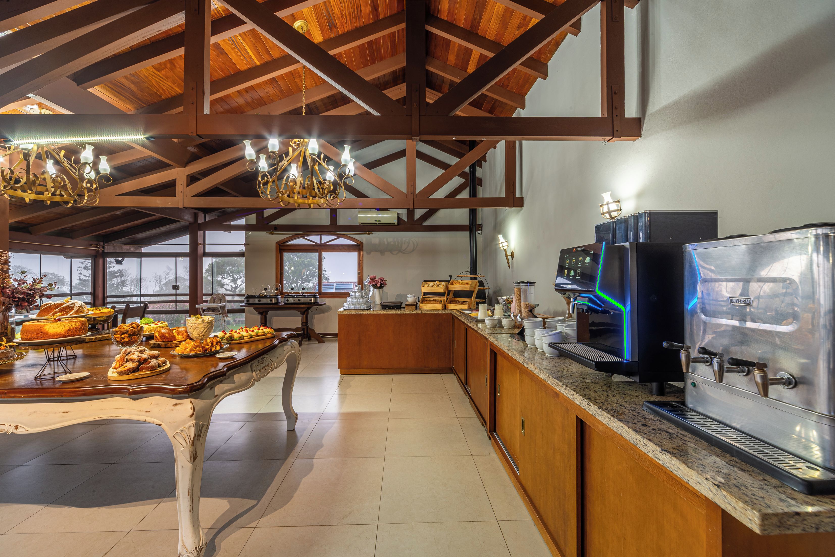 Amplia zona de cocina con un sistema de buffet, una cafetera y vistas a través de las ventanas.