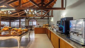 Amplia zona de cocina con un sistema de buffet, una cafetera y vistas a través de las ventanas.