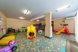 A playroom with colorful play structures, a patterned floor, and a white ceiling with lights. - Hotel Bangalôs da Serra (Gramado)
