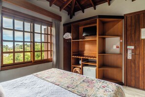 A room with a bed, a large window, a wardrobe, and a television. - Hotel Bangalôs da Serra (Gramado)