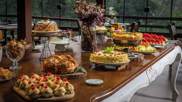 Mesa de buffet com diversos pratos e sobremesas.