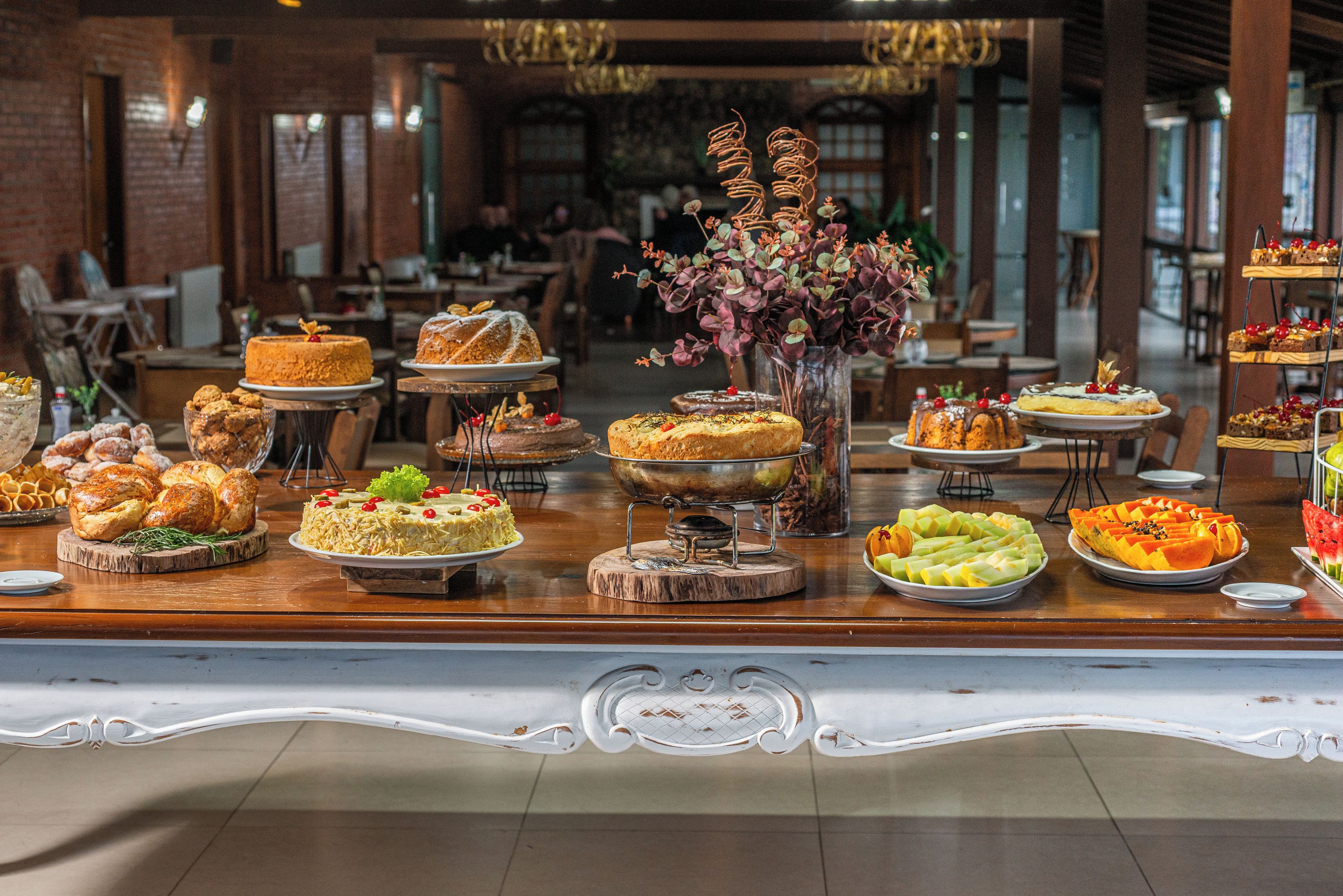 Uma mesa de buffet com diversos doces e frutas.