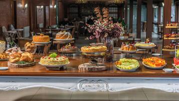 Uma mesa de buffet com diversos doces e frutas.