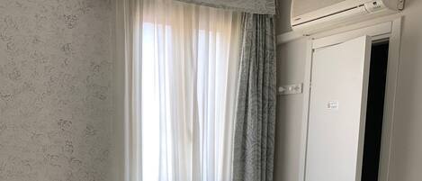 A hotel room with a bed, a desk, and a wardrobe.