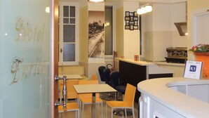 Un vestíbulo de hotel con mostrador de recepción, zona de estar y un gran ventanal con vistas a la ciudad.