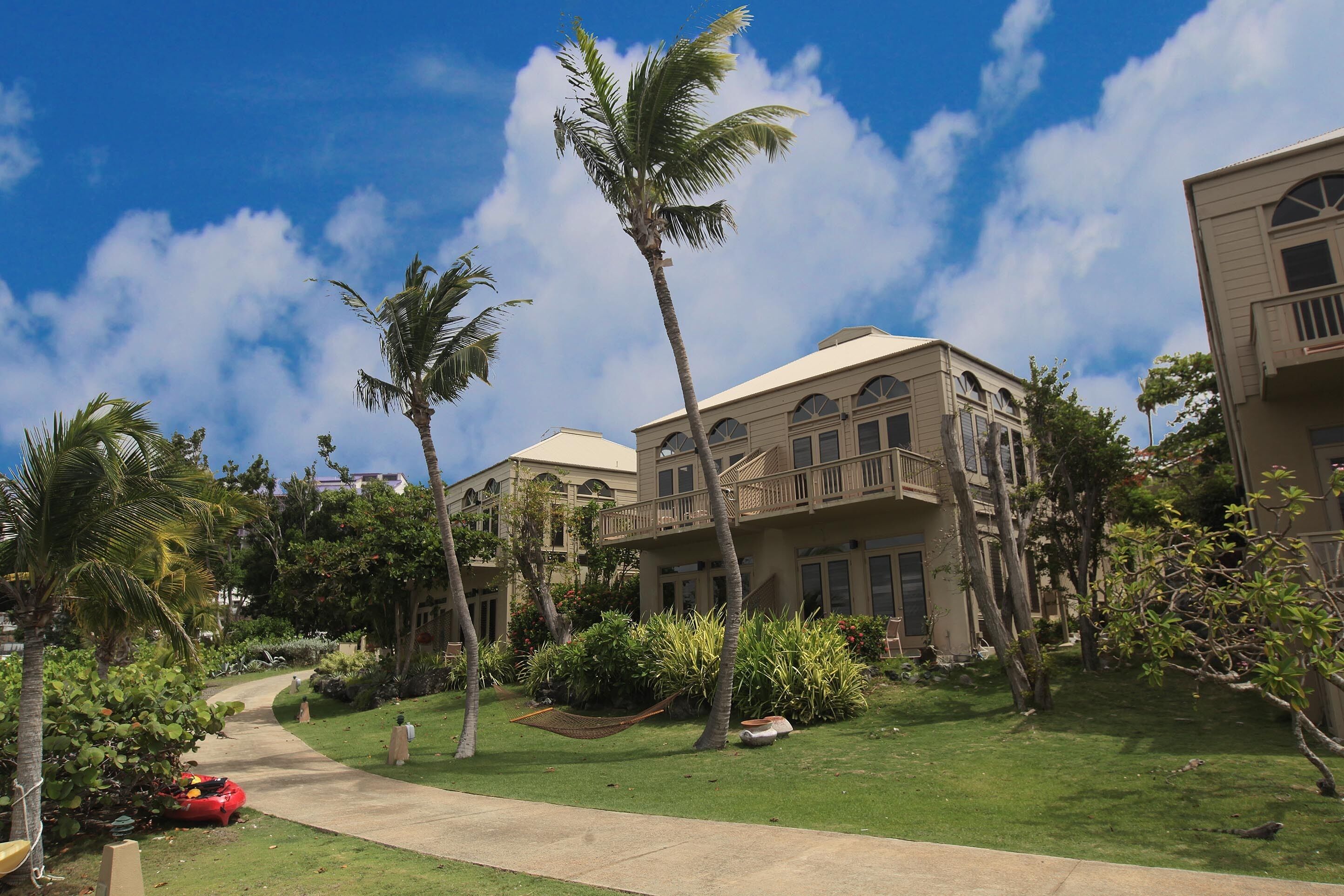 A resort with a pathway leading to a building with a balcony.